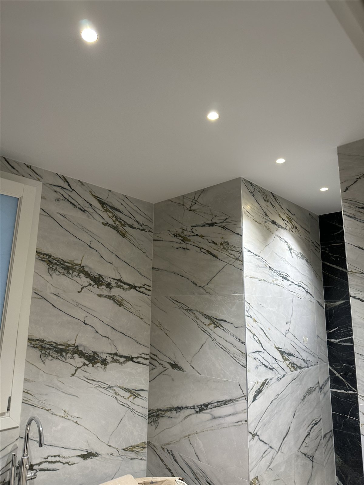 Il bagno in marmo con incassi a soffitto.