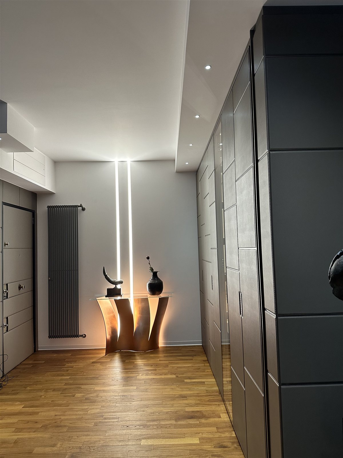 Il corridoio senza linea continua a soffitto, con un taglio verticale di luce in fondo.